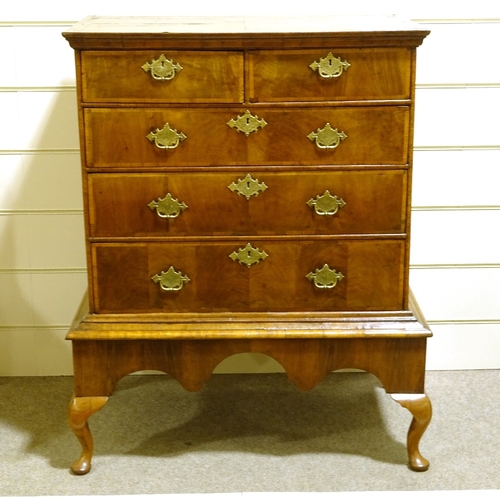 572 - An 18th century crossbanded walnut chest on stand, with brass drop handles, width 93cm, height 122cm