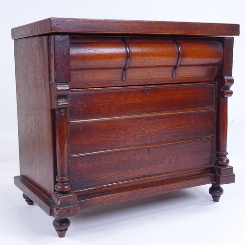 302 - A small Victorian mahogany table-top cabinet in the form of a chest of drawers, with rising lid and ... 