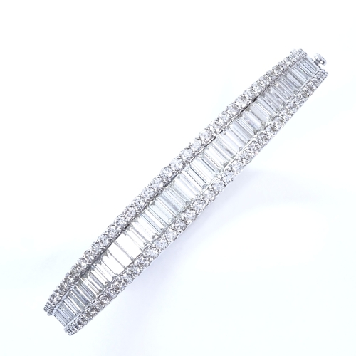 1111 - A 7.5ct diamond cluster hinged bangle/bracelet, set with graduated baguette diamonds within a round ... 