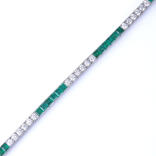 1113 - An emerald and diamond tennis line bracelet, set at alternates with calibre-cut emeralds and round b... 