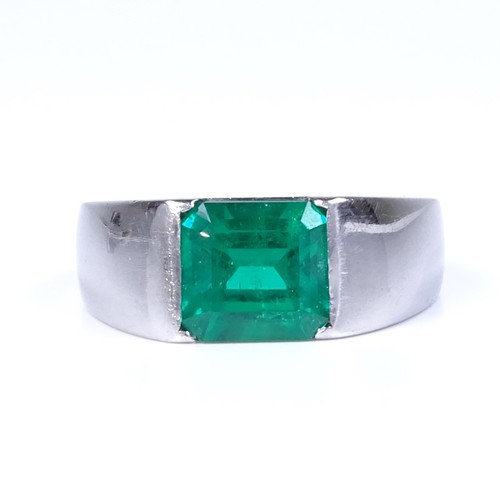 1134 - A Colombian emerald ring, rectangular emerald-cut emerald weighing approx 2.42ct bezel-set in heavy ... 