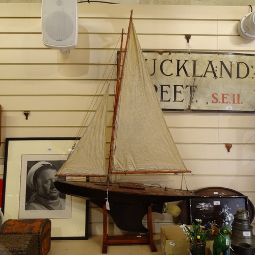 107 - A 19th century black lacquered wooden-hulled model pond yacht, with sails and rigging, hull length 8... 