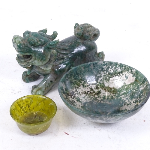 250 - A Chinese miniature carved and polished jadeite temple dog, a moss agate bowl, and another (3)