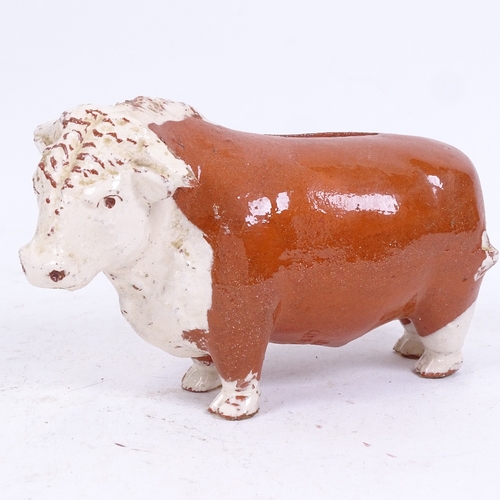 273 - A mustard shop slip glazed terracotta Bull Bank money box, possibly Coleman's, length 18cm