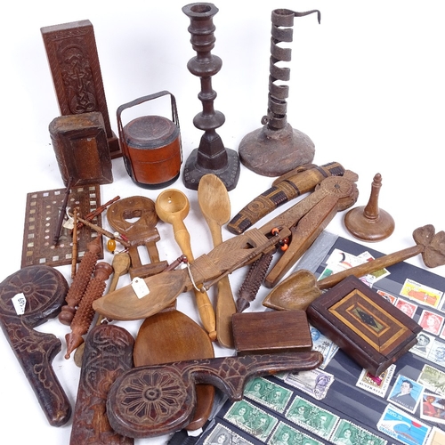 324 - A tray of treen items, including nutcracker, boxes, and an iron candlestick, and various postage sta... 