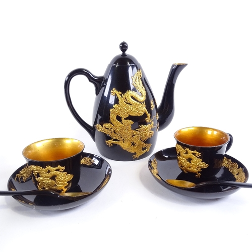 145 - A Chinese gilt black lacquer tea set, with relief dragon decoration, tray 47cm x 27cm.