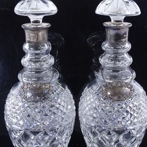 147 - A pair of cut glass silver mounted decanters, with silver labels, height 29cm.