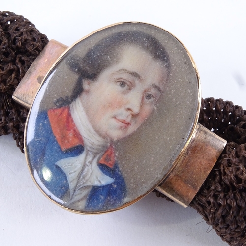 75 - A Georgian woven hair bracelet with central miniature watercolour portrait on ivory, depicting a gen... 