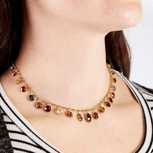 1100 - An Edwardian unmarked yellow metal gem set fringe necklace, set with graduated oval-cut gemstones, i... 
