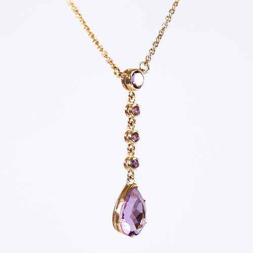 1131 - An Edwardian style 9ct gold amethyst line drop pendant necklace, set with round and pear-cut amethys... 