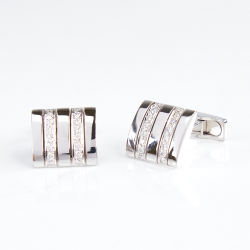 1137 - A pair of 18ct white gold diamond cufflinks, each rectangular panel set with a double-row of round b... 