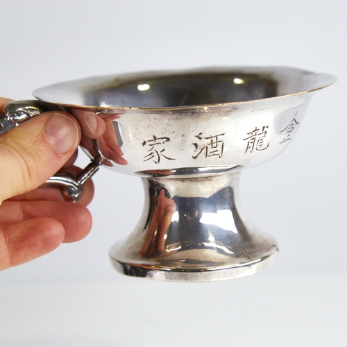 1141 - A Chinese silver pedestal bowl, plain circular form with character mark decoration and dragon handle... 