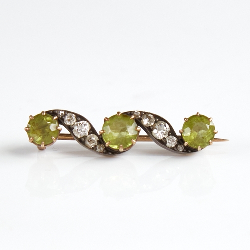 1146 - An early 20th century unmarked gold silver peridot and diamond brooch, total diamond content approx ... 