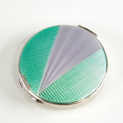 1153 - A George V Art Deco silver and enamel circular compact, engine turned green and silver enamel decora... 