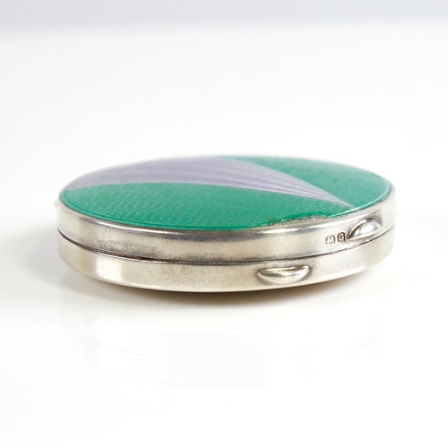 1153 - A George V Art Deco silver and enamel circular compact, engine turned green and silver enamel decora... 