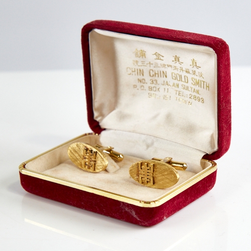 1162 - A pair of Bruneian 14ct gold cufflinks, oval panels with crosshatch decoration and applied character... 