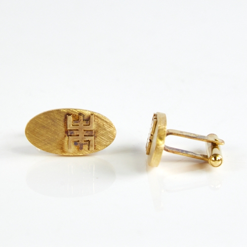 1162 - A pair of Bruneian 14ct gold cufflinks, oval panels with crosshatch decoration and applied character... 