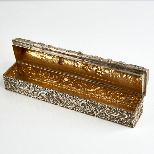 1165 - A George V silver dome-top dressing table box, long rectangular form with relief embossed decoration... 