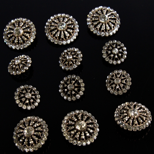 1166 - A set of 12 Georgian unmarked silver and colourless paste dress buttons, pierced sunburst design wit... 