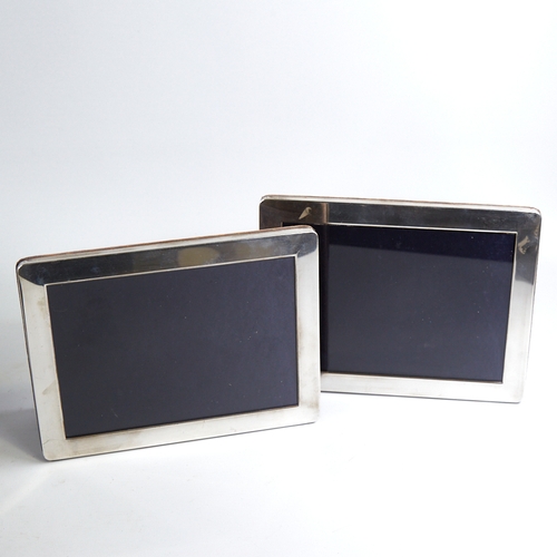 1170 - A pair of Elizabeth II silver-fronted rectangular photo frames, with velvet backings and strut stand... 