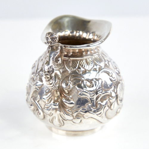 1174 - A Victorian silver squat cream jug, gourd form with relief embossed foliate decoration and figural h... 