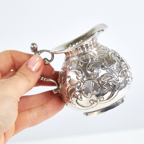 1174 - A Victorian silver squat cream jug, gourd form with relief embossed foliate decoration and figural h... 