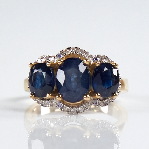 1184 - A modern 14ct gold sapphire and diamond triple-halo cluster ring, set with oval-cut sapphires and ro... 