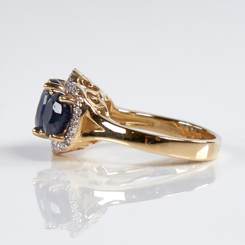 1184 - A modern 14ct gold sapphire and diamond triple-halo cluster ring, set with oval-cut sapphires and ro... 