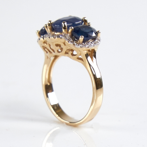 1184 - A modern 14ct gold sapphire and diamond triple-halo cluster ring, set with oval-cut sapphires and ro... 