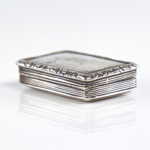 1193 - A William IV silver vinaigrette, rectangular form with cast floral border and engine turned decorati... 