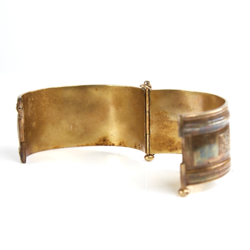 1201 - A 19th century unmarked silver? gilt hinged bangle, engraved floral panels, band width 32.7mm, inter... 