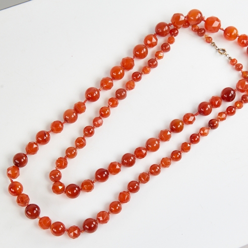 1212 - A long Vintage graduated faceted and polished carnelian bead necklace, alternating bead styles, larg... 