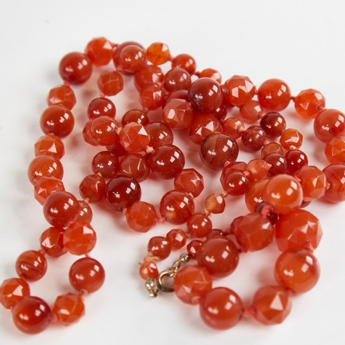 1212 - A long Vintage graduated faceted and polished carnelian bead necklace, alternating bead styles, larg... 