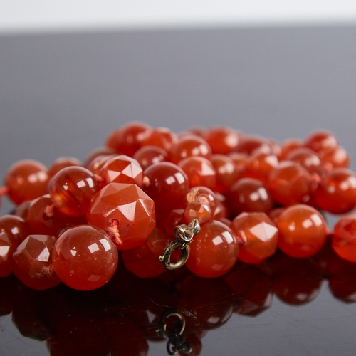 1212 - A long Vintage graduated faceted and polished carnelian bead necklace, alternating bead styles, larg... 