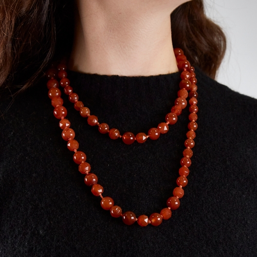 1212 - A long Vintage graduated faceted and polished carnelian bead necklace, alternating bead styles, larg... 