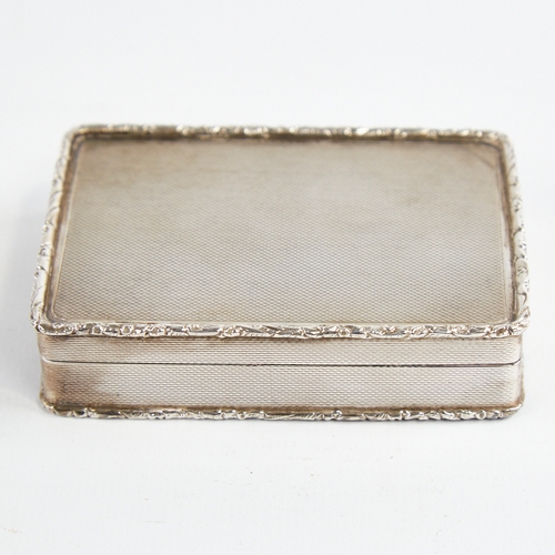 1217 - A George V silver snuffbox, plain rectangular form with cast floral border and allover engine turned... 