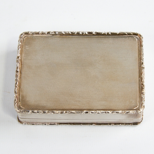 1217 - A George V silver snuffbox, plain rectangular form with cast floral border and allover engine turned... 