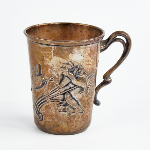 1219 - A small Art Nouveau German silver mug, relief embossed floral decoration with natural formed handle,... 