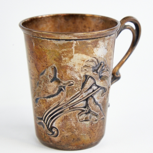 1219 - A small Art Nouveau German silver mug, relief embossed floral decoration with natural formed handle,... 