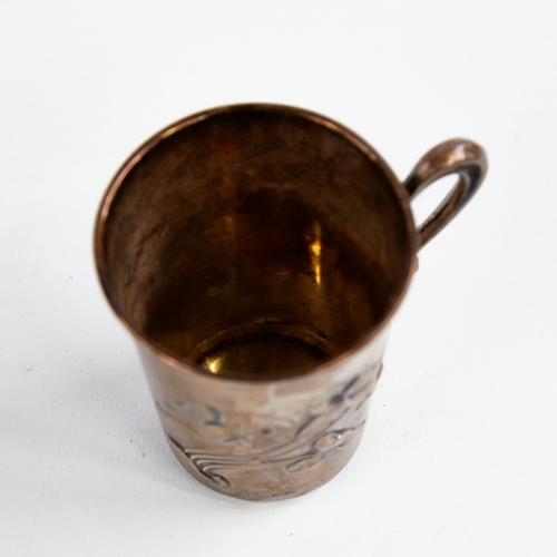 1219 - A small Art Nouveau German silver mug, relief embossed floral decoration with natural formed handle,... 