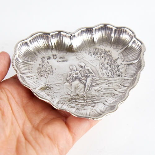 1237 - A late 19th/early 20th century German silver heart-shaped dish, Hanau, relief embossed lover decorat... 