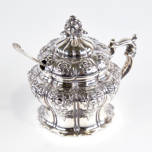 1242 - A Victorian silver mustard pot, pumpkin form with relief embossed floral decoration, floral finial, ... 