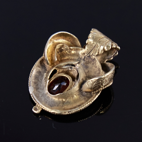 1254 - A Victorian unmarked gold garnet motif brooch, set with oval-cut garnet with allover engraved foliat... 