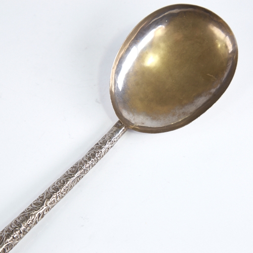 1255 - A large Indian unmarked white metal serving spoon, relief embossed foliate handle, length 26cm, 1.6o... 