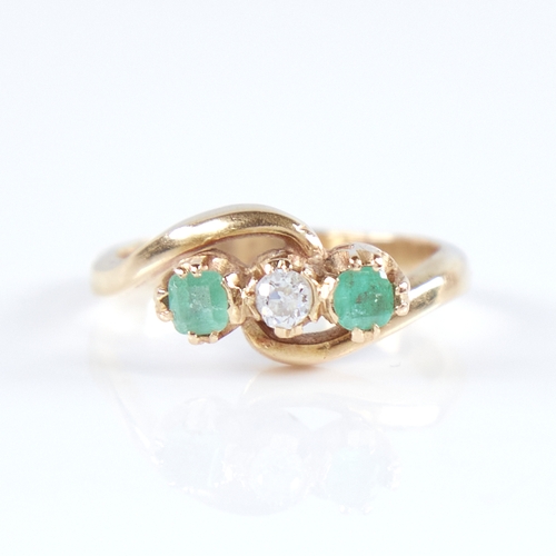 1265 - An early 20th century unmarked high carat gold 3-stone emerald and diamond crossover ring, set with ... 