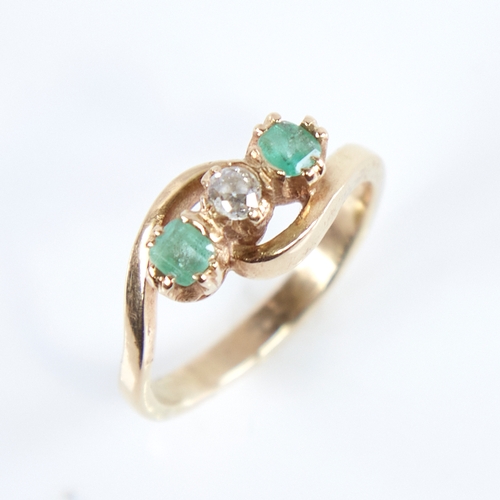 1265 - An early 20th century unmarked high carat gold 3-stone emerald and diamond crossover ring, set with ... 