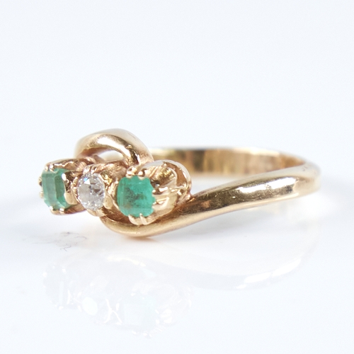 1265 - An early 20th century unmarked high carat gold 3-stone emerald and diamond crossover ring, set with ... 