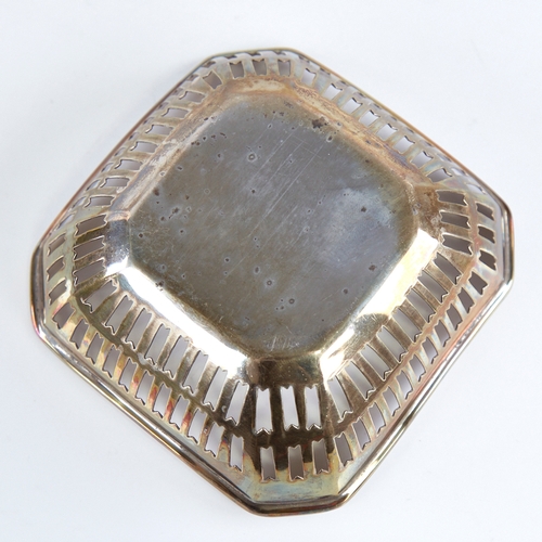 1266 - A small George V silver bon bon dish, canted square form with pierced gallery and central enamelled ... 