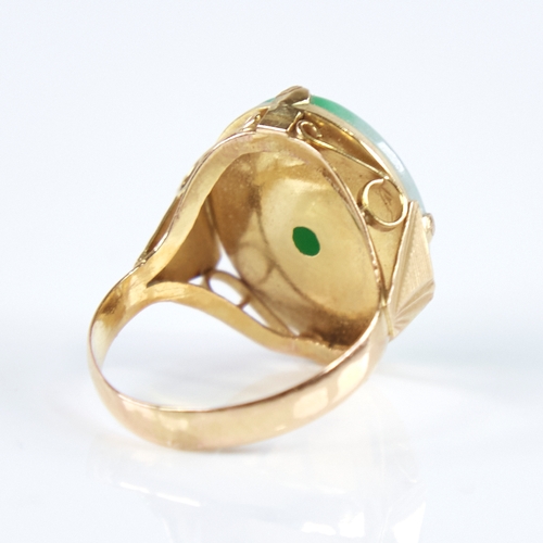 1270 - A Vintage Chinese unmarked high carat gold cabochon jade panel ring, ribbed shoulders with openwork ... 