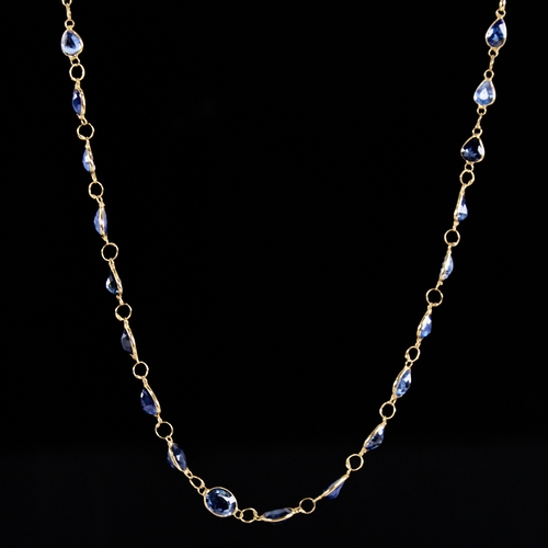 1287 - A modern handmade unmarked high carat gold sapphire line necklace, set with oval and pear-cut sapphi... 